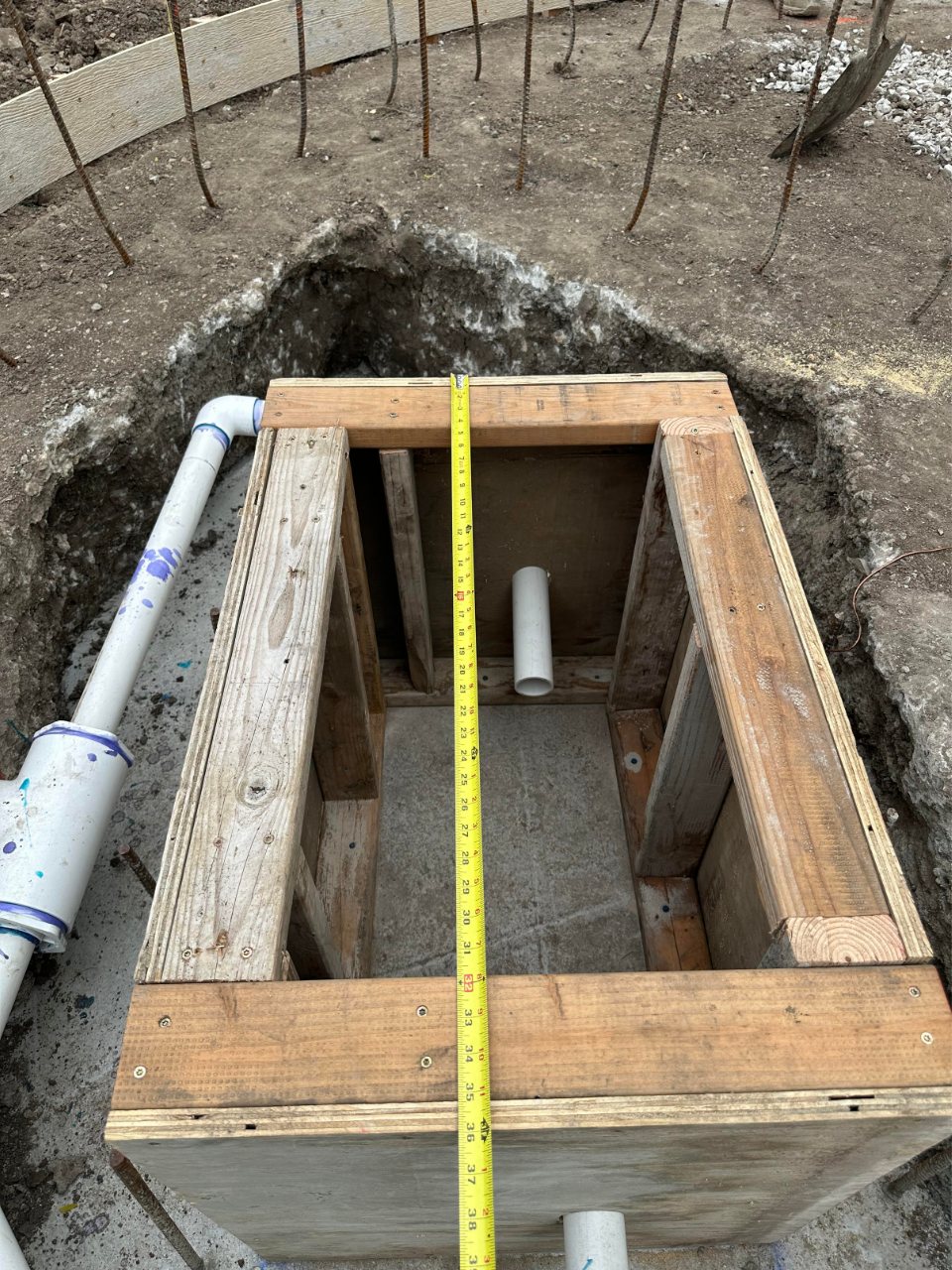 Foundation trench with pipes prepared for custom fountain water feature