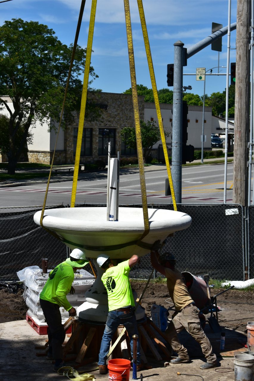 Landscape crew assembling stacked stone fountain base for residential fountain in Johnson County